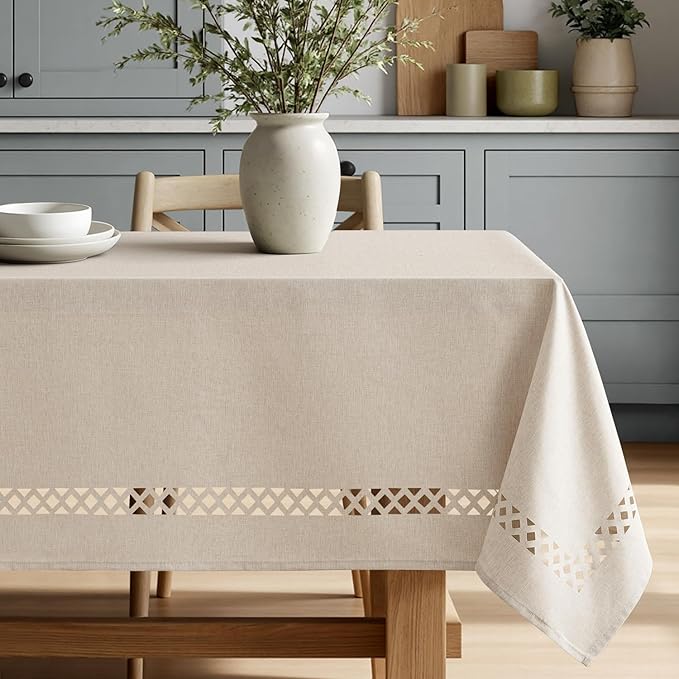 Beige rectangular linen-polyester blend tablecloth with decorative cutwork pattern, waterproof, stain-resistant, and shrink-resistant, measuring 52x70 inches.  Farmhouse style, suitable for dining rooms, weddings, parties, and outdoor picnics.